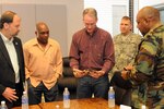 Governor Dennis Daugaard (center) accepts a token of appreciation from Mr. Lamure Latour, Suriname Minister of Defense, at the Capitol, Friday, June 17, 2011. The South Dakota National Guard hosted dignitaries from the Republic of Suriname for a week in June.  Dignitaries were shown various military training associated with the annual Golden Coyote training exercise, which brought 2,100 National Guard Soldiers and Airmen from across the U.S. to the Black Hills for the two-week training event.  They were also shown ongoing missions by South Dakota's Soldiers and Airmen conducting flood relief related missions in the state's capitol.  The South Dakota-Suriname State Partnership Program was formally established in August 2006 to develop mutually beneficial partnerships between the two entities.