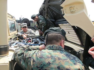 Army Chief Warrant Officer 3 Craig Evans, supervisory equipment specialist with the Kentucky National Guard, goes through the maintenance inspection process of a high mobility multipurpose wheeled vehicle with the members of the Ecuadorian military at a visit on Boone National Guard Center in Frankfort, Ky.