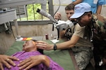 Air Force Maj. Nathaniel Duff and Royal Cambodian Armed Forces Capt. Sok Heng examine the ear of a Cambodian woman during Operation PACIFIC ANGEL 11-1 Aug. 8, 2011, in Bak Klarng, Cambodia. The operation supports U.S. Pacific Command’s capacity-building efforts by partnering with other governments in the region to provide medical, dental, optometry and engineer assistance to their citizens. Major Duff is an ear, nose and throat surgeon assigned to the 154th Medical Group, Hawaii Air National Guard. Captain Heng is a medic in the Royal Cambodian Air Force.