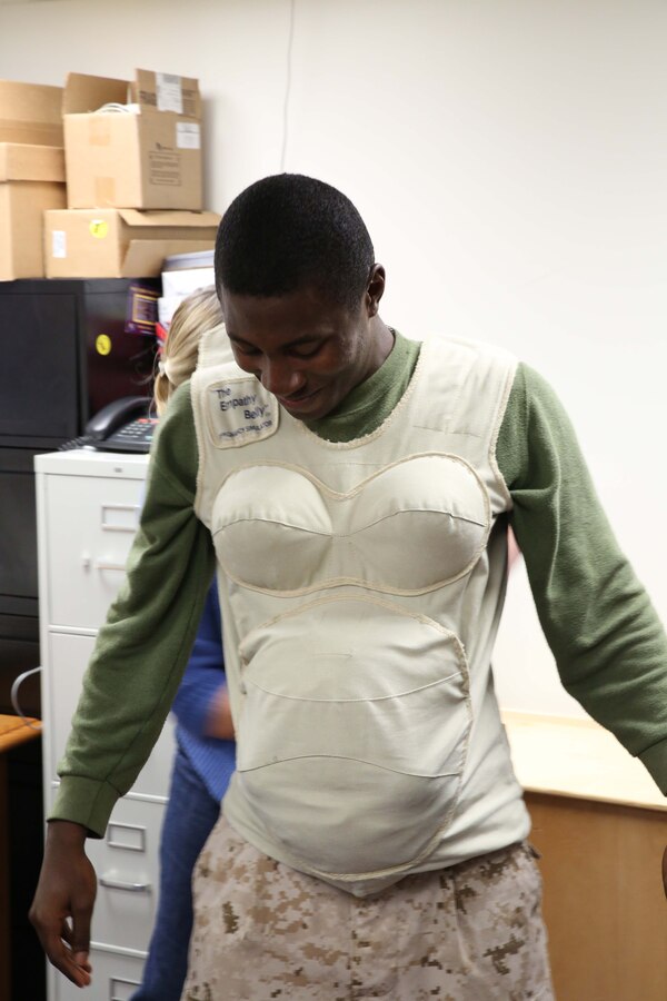 Lcpl. Montrel Calhoun, regents clerk, dons the empathy belly during The Amazing Race, professional military education event, aboard Marine Corps Base Quantico on Oct. 11, 2013. The race consisted of 17 events that participants took part in to get clues and ultimately run the best time.
