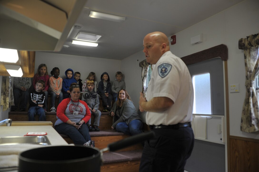 Students from John H. Russell Elementary listen to a fire safety brief, given by a fire instructor from Quantico Fire and Emergency Services on Oct. 8, 2013. The students must use what they learned and spot the fire hazards in the room.