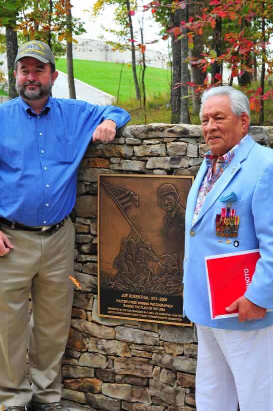 Participants of the Joe Rosenthal plaque dedication ceremony posed for a picture around the plaque at the National Museum of the Marine Corps on Oct. 10, 2013. The ceremony was held on the 102nd anniversary of Rosenthal’s birthday. 
