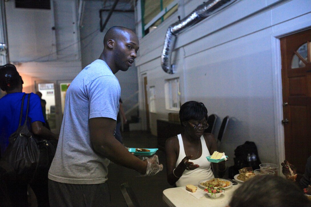 NEW ORLEANS – Lance Cpl. Christopher Cox, an administrative specialist at 4th Logistics Group, serves desserts at tables at the New Orleans Mission, Oct. 10. The NOM is staffed mostly by volunteers like Cox that help run its daily operations, from feeding the community’s disadvantaged residents to providing free boarding for the homeless. (U.S. Marine Corps photo by Lance Cpl. Tiffany Edwards)