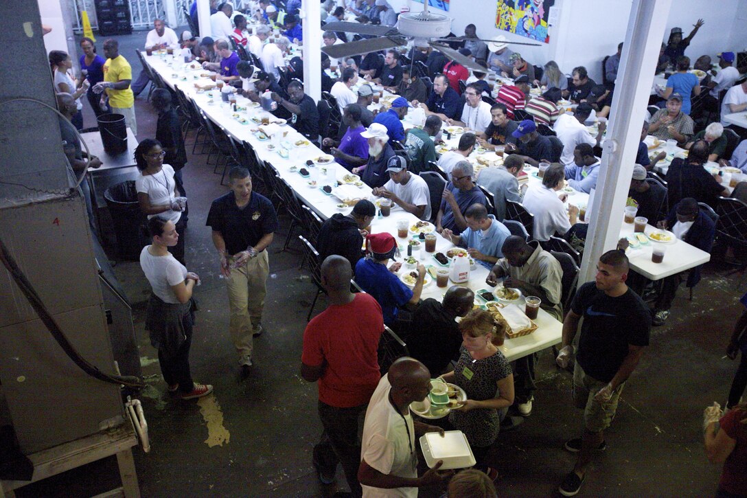 Marine volunteers walk around the dining room at the New Orleans Mission, serving the assembled “disciples” at their evening dinner, Oct. 10. The NOM is one of many volunteer opportunities available to Marines at MARFORRES every week.. (U.S. Marine Corps photo by Lance Cpl. Tiffany Edwards)