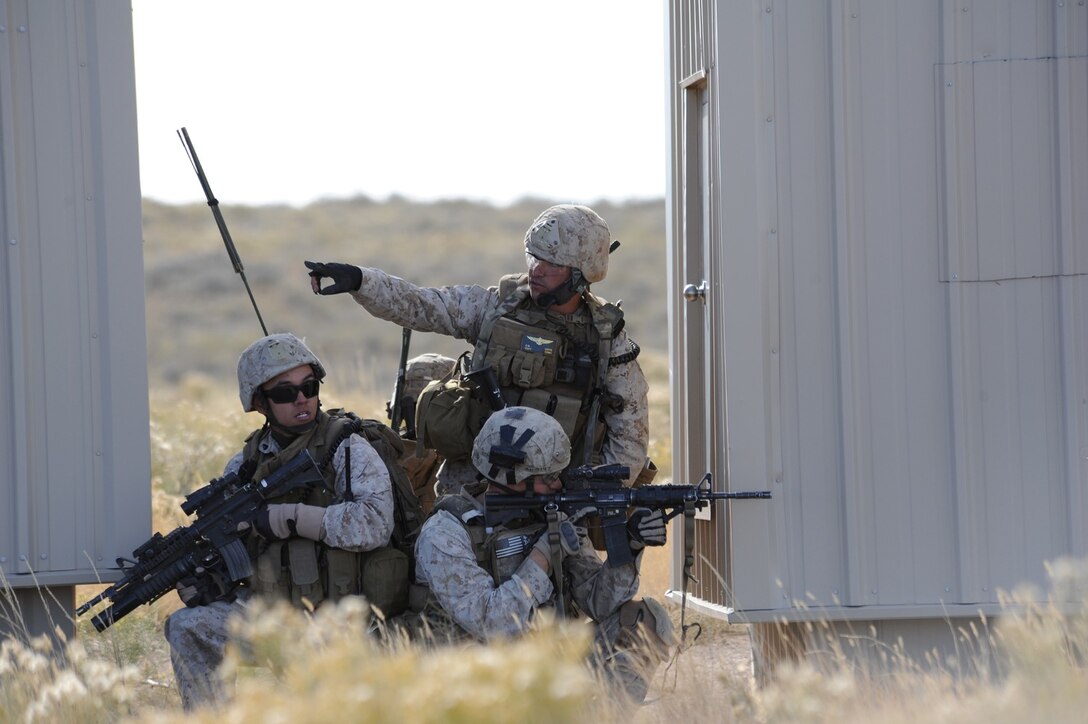 U.S. Marine Capt. Erich Lloyd, 1st Air Naval Gunfire Liaison Company forward air controller deployed from Camp Pendleton, Calif., directs team movements during an exercise urban combat scenario during exercise Mountain Roundup 2013 at Juniper Butte Range, about 70 miles from Mountain Home Air Force Base, Idaho, Oct. 8, 2013. Lloyd, a prior-enlisted crew chief, used U.S. Navy AV-8B Harriers and Republic of Singapore air force F-15SG Strike Eagles air assets to neutralize enemy forces. (U.S. Air Force photo by Master Sgt. Kevin Wallace/RELEASED)