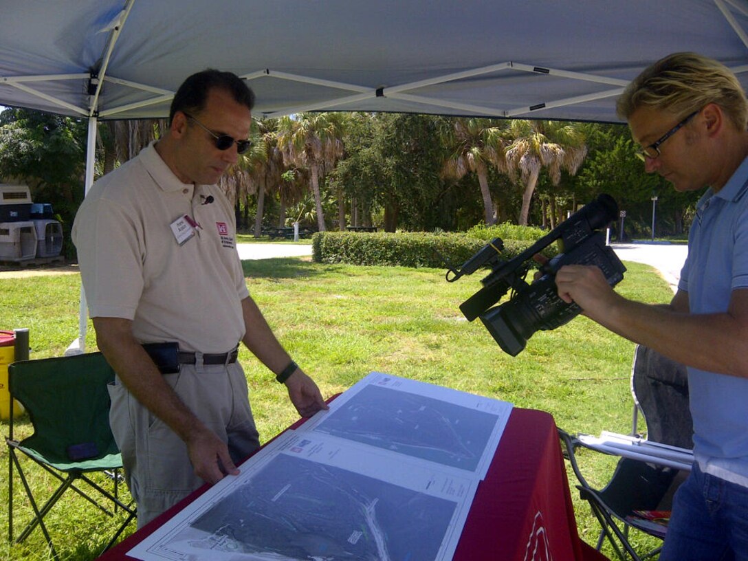 Frank Araico (left), project manager for the Mullet Key Bombing and Gunnery Range Formerly Used Defense Site, shows a local news reporter maps that detail where military activities took place on the site during World War II. A Remedial Investigation/Feasibility Study is currently under way. 