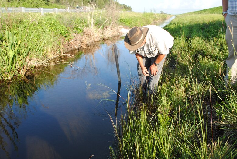 Calvin Grinslade, civil engineering technician with the South Florida Operations Office, takes a close look at the toe ditch near Herbert Hoover Dike as part of the weekly inspections conducted this summer on the earthen structure surrounding Lake Okeechobee. The intent of the inspections is to identify minor issues and address them before they turn into major problems. 