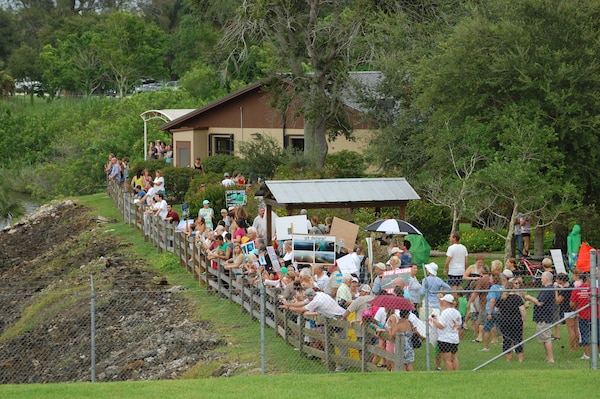 Crowds line the fence during a demonstration held at the St. Lucie Lock & Dam August 3 to protest the discharges from Lake Okeechobee to the St. Lucie and Caloosahatchee River Estuaries. An estimated 5,000 people attended the event. 