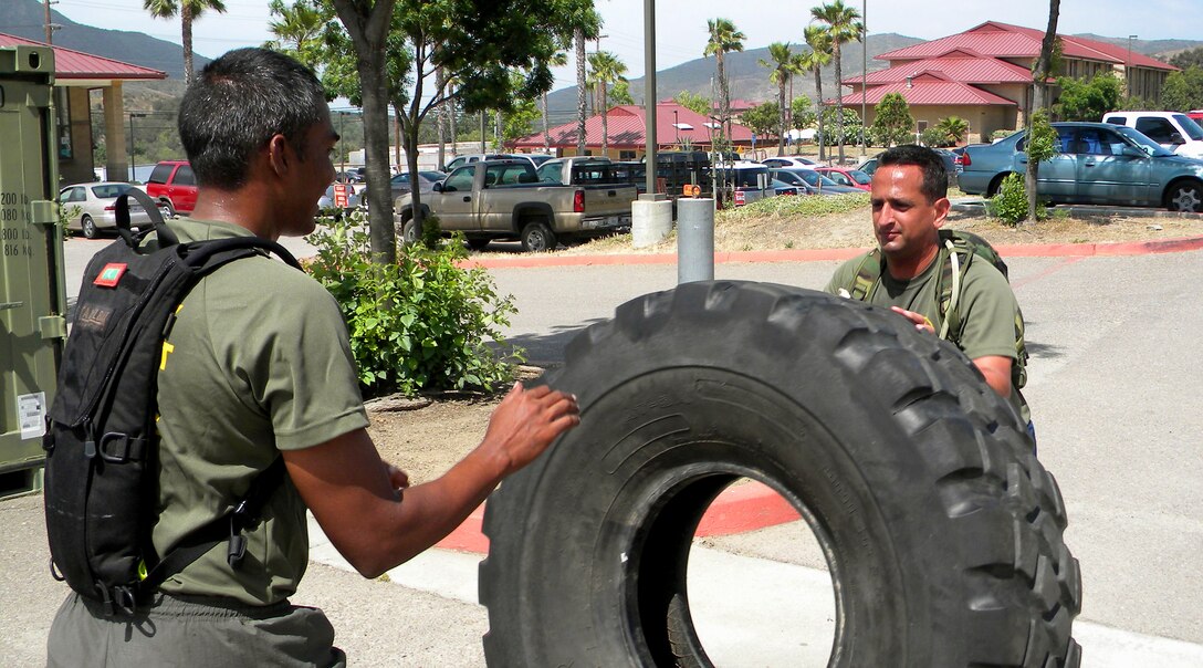 Master Sgt. Ricardo Russo, right, performs tire flips with a U.S. Marine Corps Staff Non-Commissioned Officer Academy classmate, during a physical training session at Camp Pendleton, Calif. Russo was the only Air Force member in his class, and was hand-picked to attend the course. (Courtesy photo)