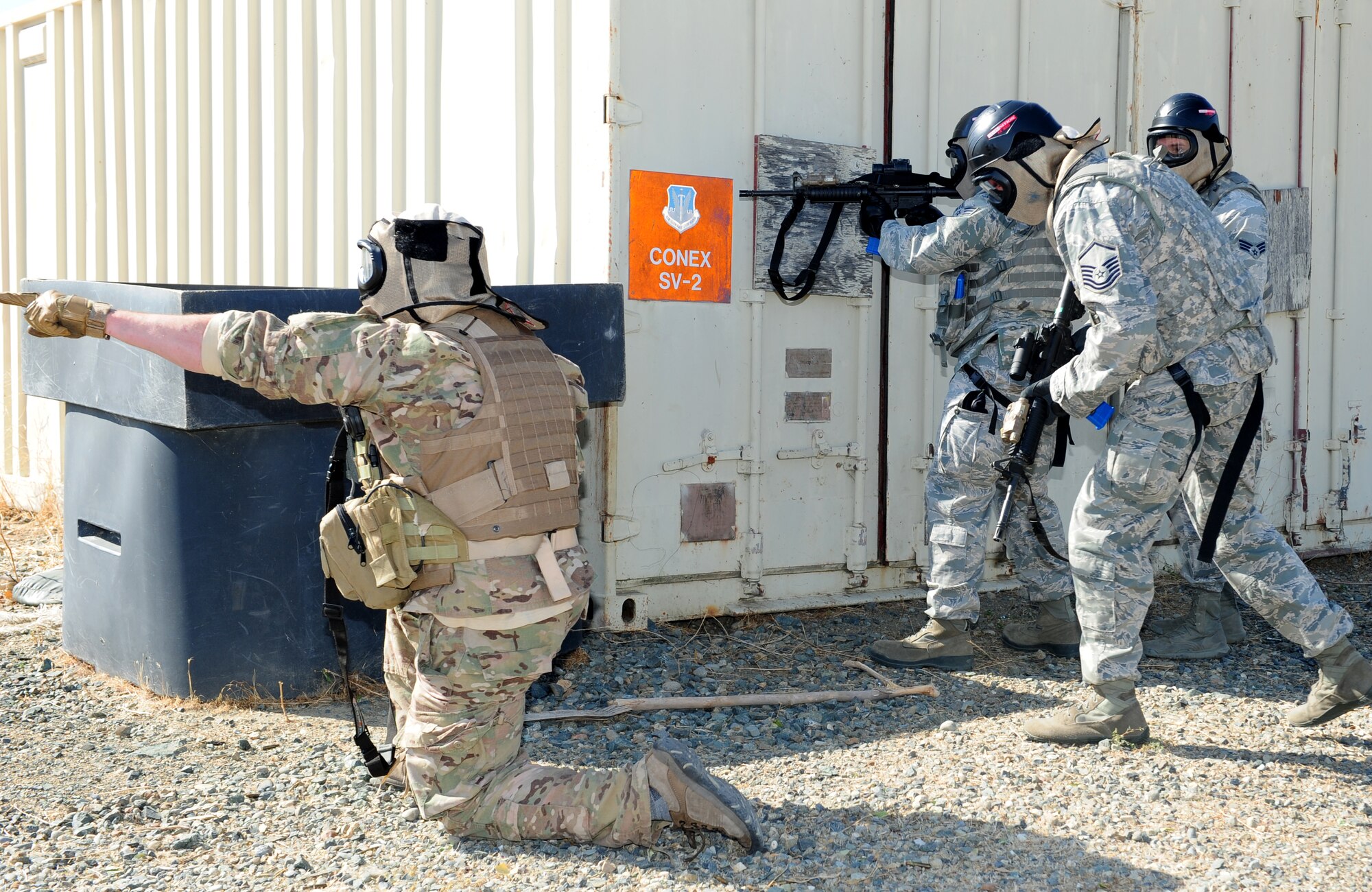 An Air Force contractor identifies a simulated enemy target while Airmen from the 9th Security Forces Squadron prepare to engage the threat. Contractors served as the subject matter experts during a pilot-rescue exercise, providing valuable insight to the Airmen. (U.S. Air Force photo by Airman 1st Class Bobby Cummings/Released)