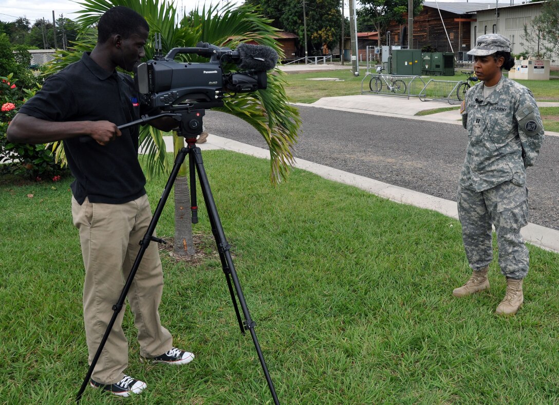 U.S. Army Sgt. Kwadwo Frimpong of American Forces Network records U.S. Army Capt. Yolanda Burnom, Joint Task Force-Bravo Medical Element, as she gives a holiday "shoutout" to her friends and family back in the United States, Oct. 15, 2013.  Personnel assigned to Joint Task Force-Bravo have the opporunity to record holiday greetings for loved ones, which are made available online for those stateside to view and sent to hometown news stations for broadcast.  (U.S. Air Force photo by Capt. Zach Anderson)