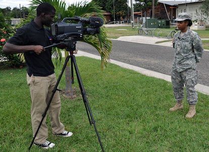 U.S. Army Sgt. Kwadwo Frimpong of American Forces Network records U.S. Army Capt. Yolanda Burnom, Joint Task Force-Bravo Medical Element, as she gives a holiday "shoutout" to her friends and family back in the United States, Oct. 15, 2013.  Personnel assigned to Joint Task Force-Bravo have the opporunity to record holiday greetings for loved ones, which are made available online for those stateside to view and sent to hometown news stations for broadcast.  (U.S. Air Force photo by Capt. Zach Anderson)