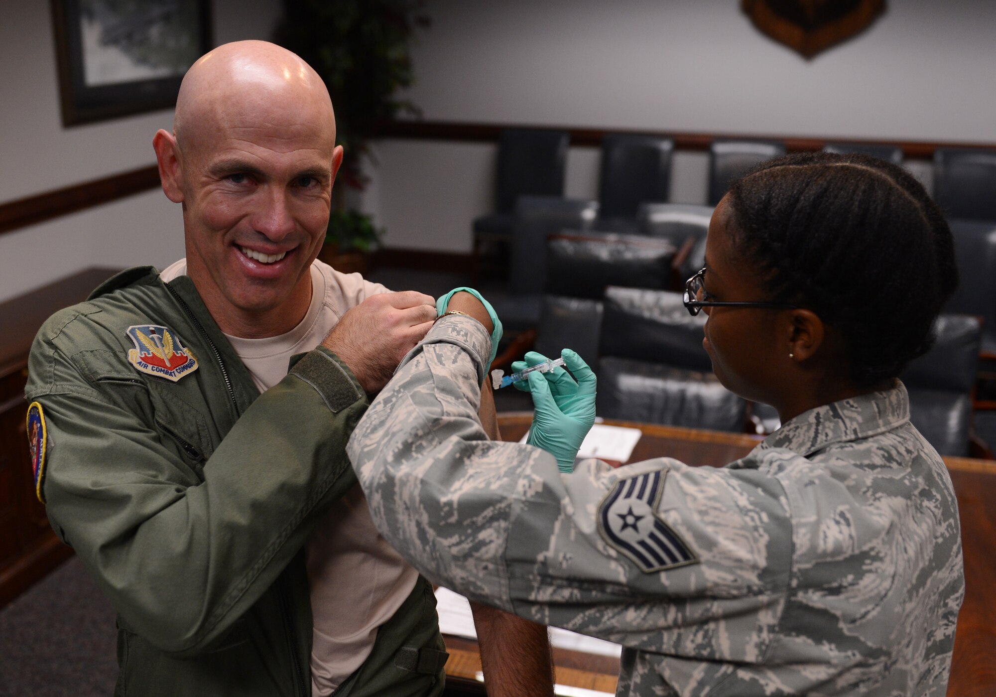 U.S. Air Force Staff Sgt. Althia Hudson, 20th Medical Group medical technician, gives Col. Clark Quinn, 20th Fighter Wing vice commander, his annual flu vaccination, Shaw Air Force Base, S.C., Oct. 11, 2013. Annual flu vaccinations are mandatory for all active-duty and medical personnel. (U.S. Air Force photo by Senior Airman Tabatha Zarrella/Released) 
