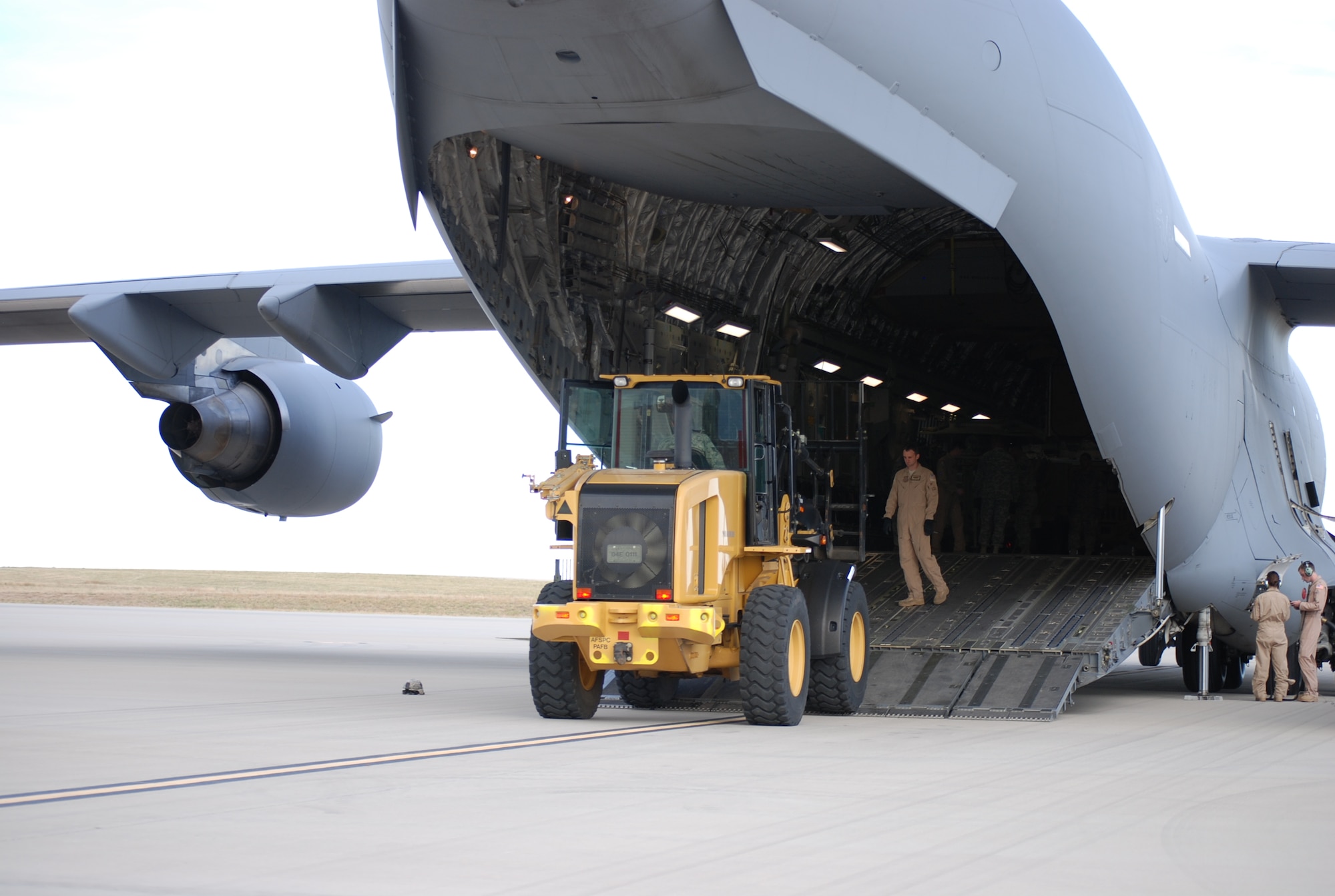 COLORADO SPRINGS, Colo. – A forklift is slowly backed out of a C-17 under the watchful eye of a C-17 loadmaster Oct. 9 at the Fort Carson Arrival/Departure Airfield Control Group. The loadmaster ensures safety and that no damage is done to the aircraft during loading and unloading. (U.S. Air Force photo/Michael Golembesky)