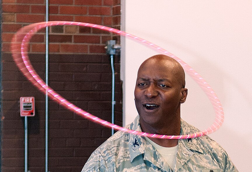 Col. Carl Jones, 90th Missile Wing vice commander, works the hula-hoop for 10 seconds as he competes in the F.E. Warren Air Force Base Domestic Violence Awareness Confidence Course Challenge in the Fall Hall Community Center Oct. 10, 2013. The event, sponsored by the Domestic Violence Awareness Committee, included informational displays and physical challenges to bring attention to domestic violence. (U.S. Air Force photo by R.J. Oriez)