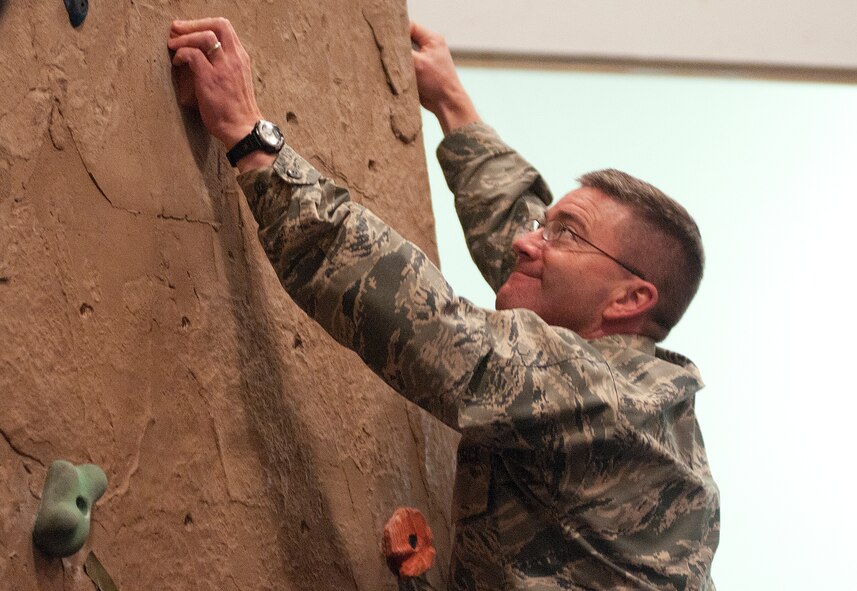 Col. Hans Ritschard, 90th Medical Group commander, navigates his way through the rock wall portion of the F.E. Warren Air Force Base Domestic Violence Awareness Confidence Course Challenge in the Fall Hall Community Center Oct. 10, 2013. The event, sponsored by the Domestic Violence Awareness Committee, included informational displays and physical challenges to bring attention to domestic violence. (U.S. Air Force photo by R.J. Oriez)