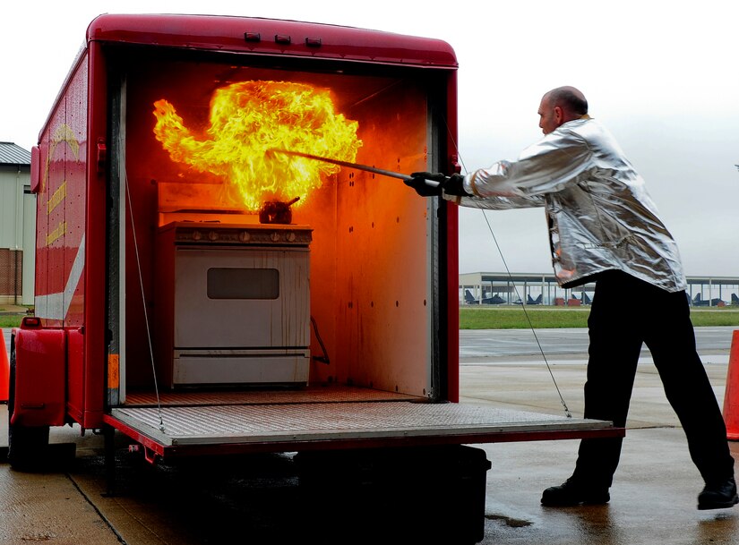 Christian Jacobs, 633rd Civil Engineer Squadron fire inspector, demonstrates grease fire dousing techniques during Fire Prevention Week at Langley Air Force Base, Va., Oct. 11, 2013. This year, Fire Prevention Week focused on the importance of preventing kitchen fires, the most common form of house fires. (U.S. Air Force photo by Airman Areca T. Wilson/Released) 