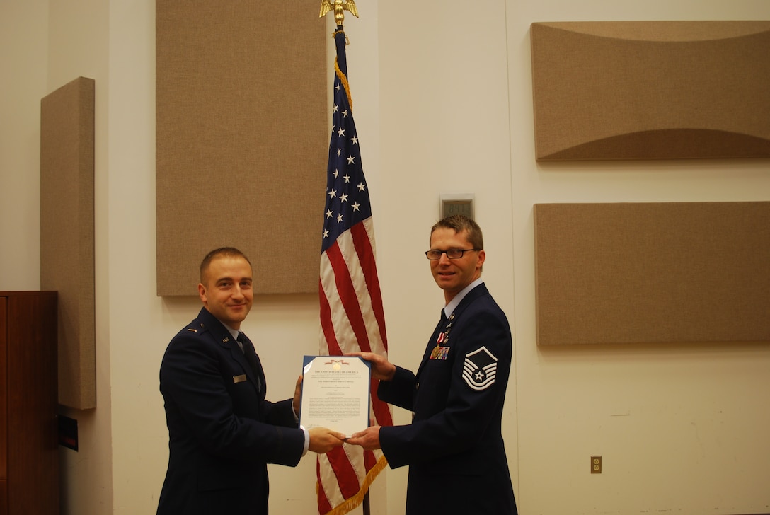 2nd Lieutenant Justin W. Lewis presents Master Sergeant Ryan Heseltine an Air Force Meritorious Service Medal