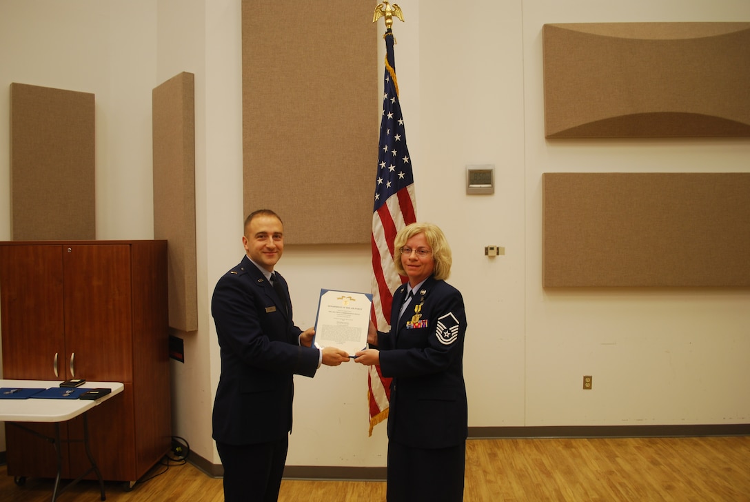2nd Lieutenant Justin W. Lewis presents Master Sergeant Amy Lynch an Air Force Commendation Medal
