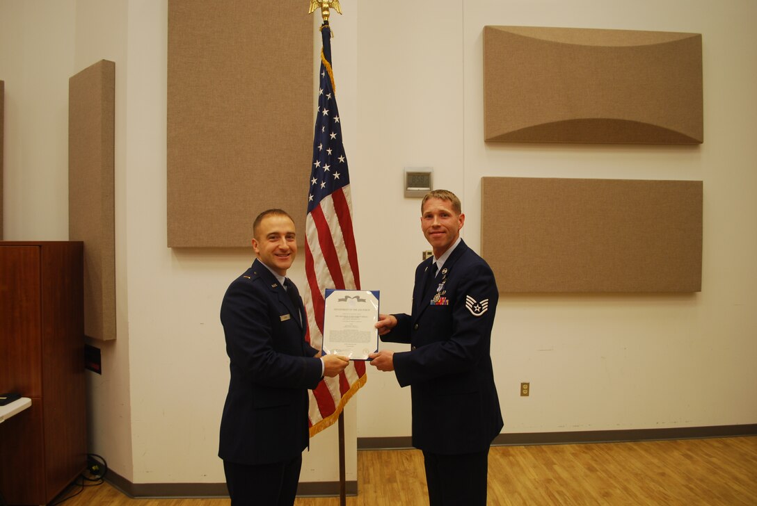 2nd Lieutenant Justin W. Lewis presents Staff Sergeant Brian Connolly with an Air Force Achievement Medal