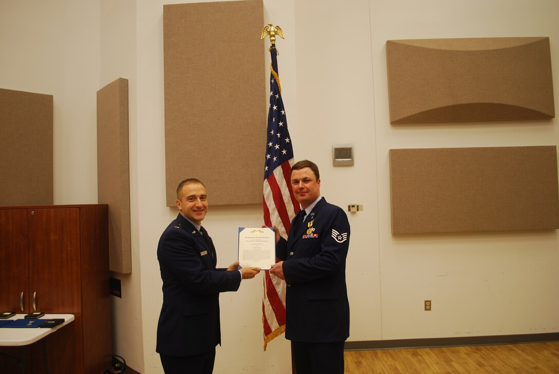 2nd Lieutenant Justin W. Lewis presents Staff Sergeant Michael Mannella with an Air Force Commendation Medal