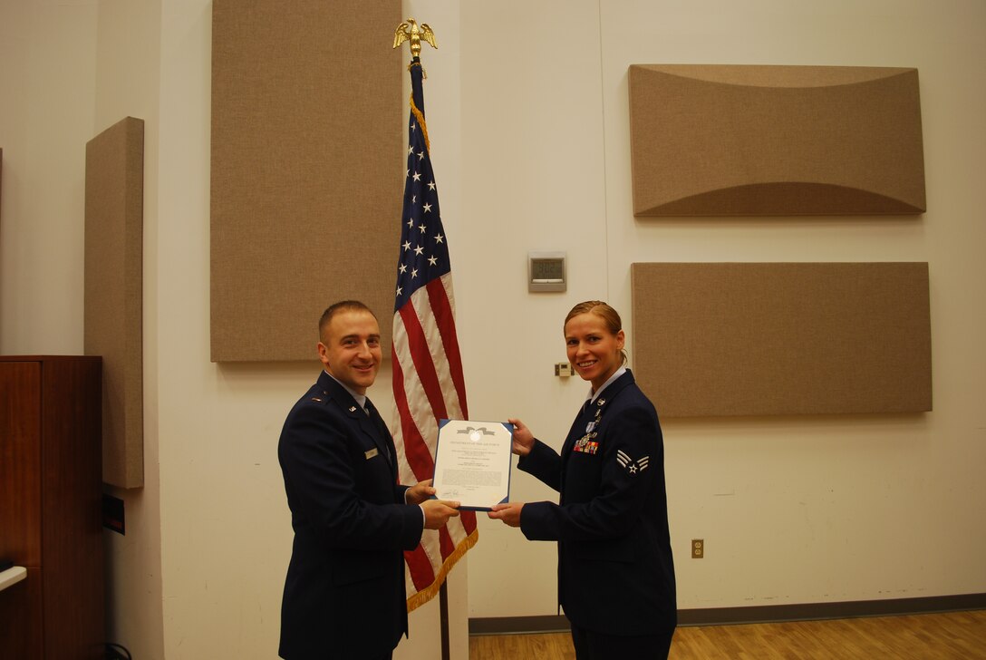 2nd Lieutenant Justin W. Lewis presents Senior Airman Michelle Hooper with an Air Force Achievement Medal