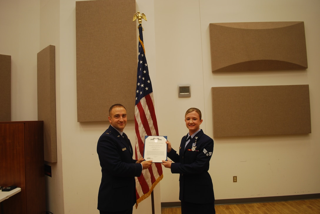 2nd Lieutenant Justin W. Lewis presents Senior Airman Kelly Fussell with an Air Force Achievement Medal