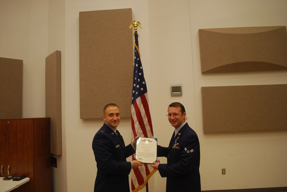 2nd Lieutenant Justin W. Lewis presents Airman 1st Class Mark Oates with an Air Force Achievement Medal 