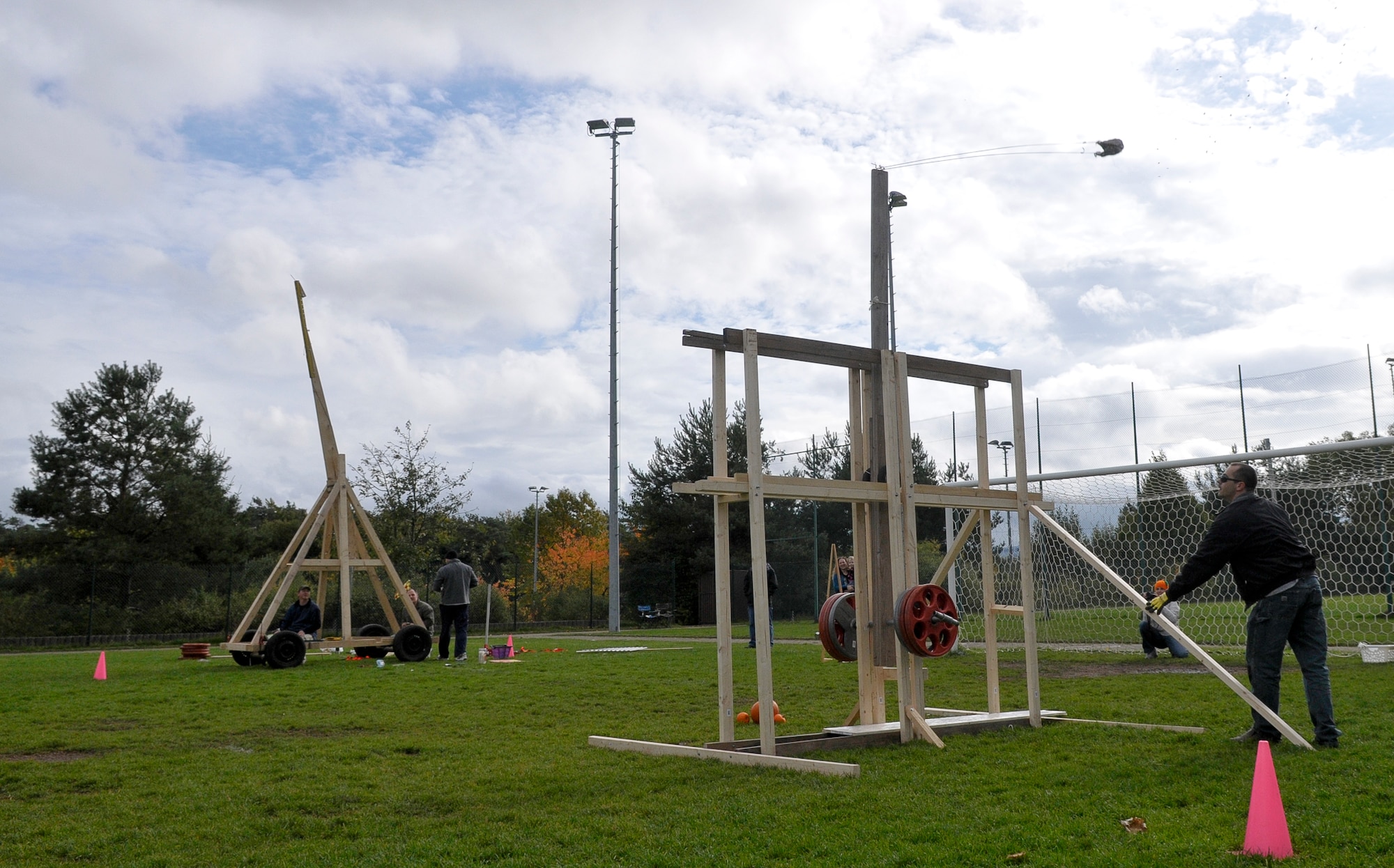 Tech. Sgt. Jason Crawford, 721st Aerial Port Squadron passenger service supervisor, launches one last pumpkin during the second annual Pumpkin Chuckin’ competition at Donnelly Park, Oct. 14, 2013, Ramstein Air Base, Germany. The alternative design used for the trebuchet enabled the siege engine to be lighter, but not able to launch the pumpkins far enough for a victory over the other team’s massive machine. The competition began after the two teams assembled their catapults and launched a few test pumpkins. After the test firing was over, each team had three measured launches with the single longest toss deciding the victor. The event was held in an effort to raise morale and promote esprit de corps within the KMC. (U.S. Air Force photo/Senior Airman Jose L. Leon)