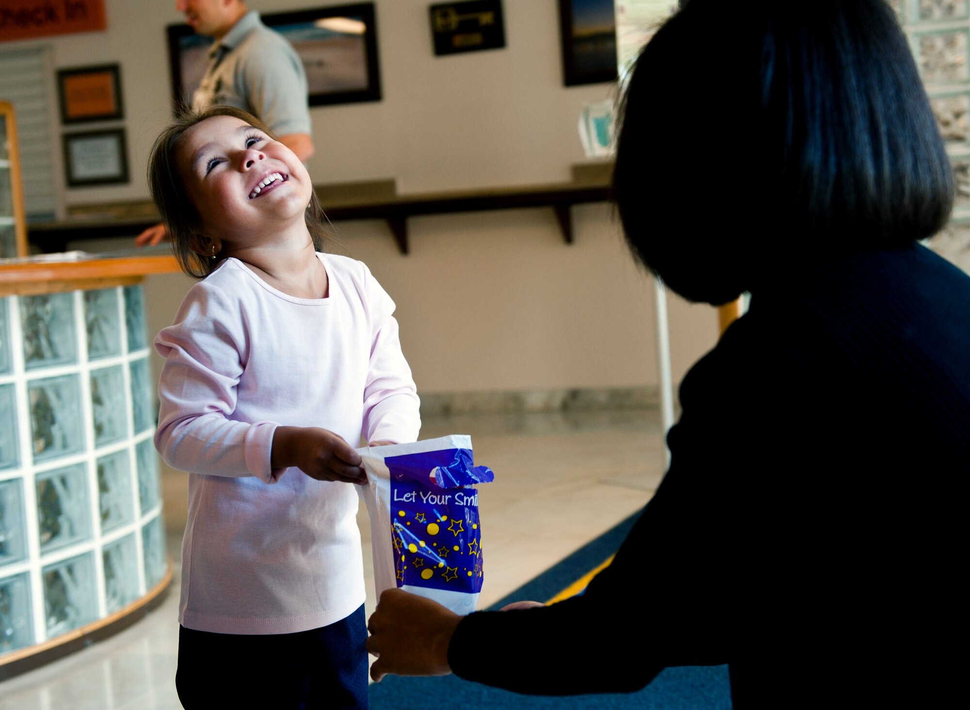 A military dependant receives a gift bag from Master Sgt. Francesca Seehausen, 39th MDOS dental flight chief, after her dental screening Oct. 12, 2013, at Incirlik Air Base, Turkey. The dental clinic set aside this Saturday for military dependents who might not get the opportunity to have appointments to receive a screening. (U.S. Air Force photo by Senior Airman Daniel Phelps/Released)