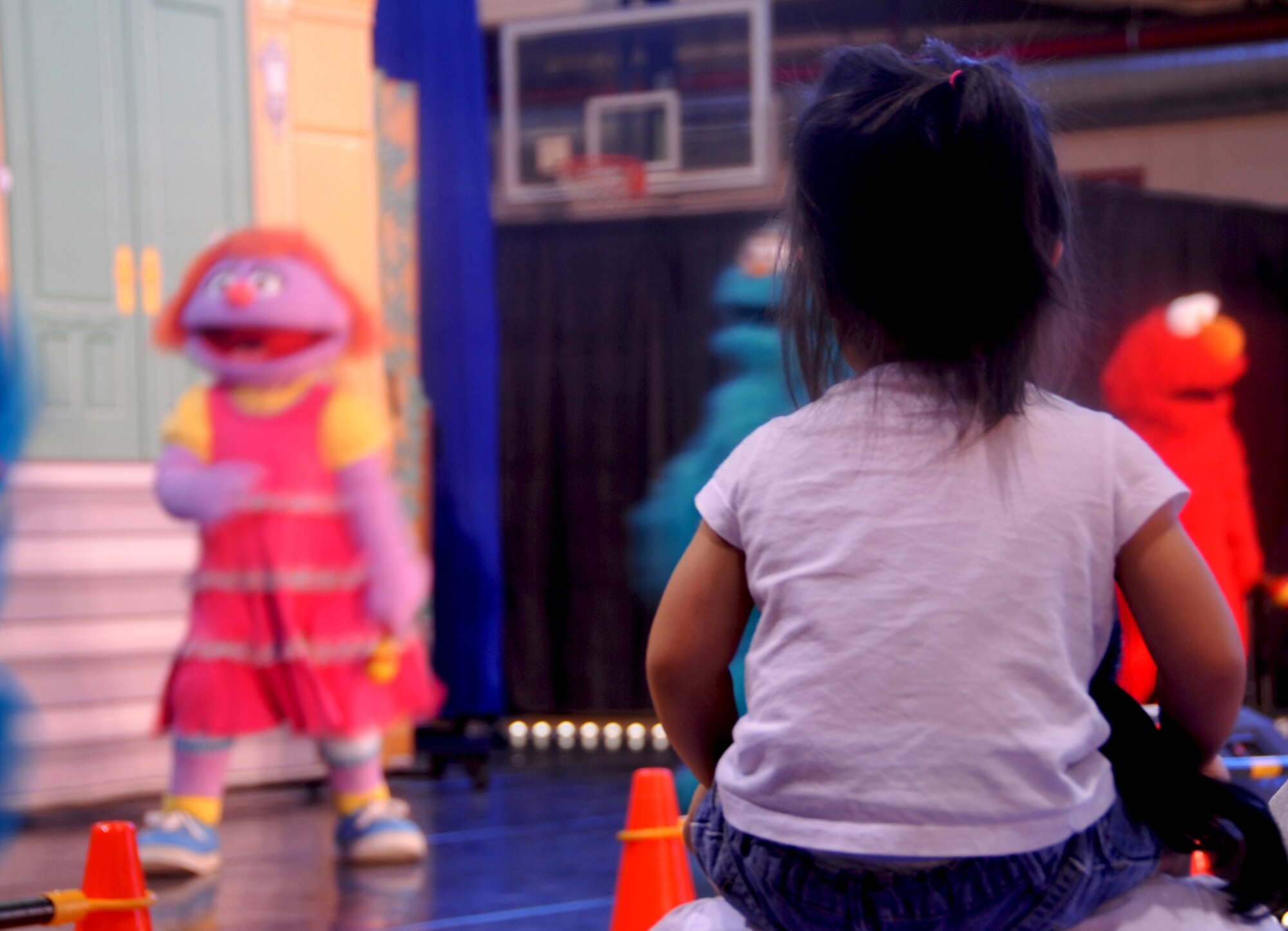 A little Mustang watches as performers from Sesame Street sing a medley of songs at the Fitness Center on Osan Air Base, Republic of Korea, Oct. 11, 2013. The performance was part of the Sesame Street Workshop and United Service Organization’s “Talk, Listen, Connect” program that was launched in 2006 as a bilingual educational outreach initiative designed for military families and their children. (U.S. Air Force photo/Senior Airman Kristina Overton)