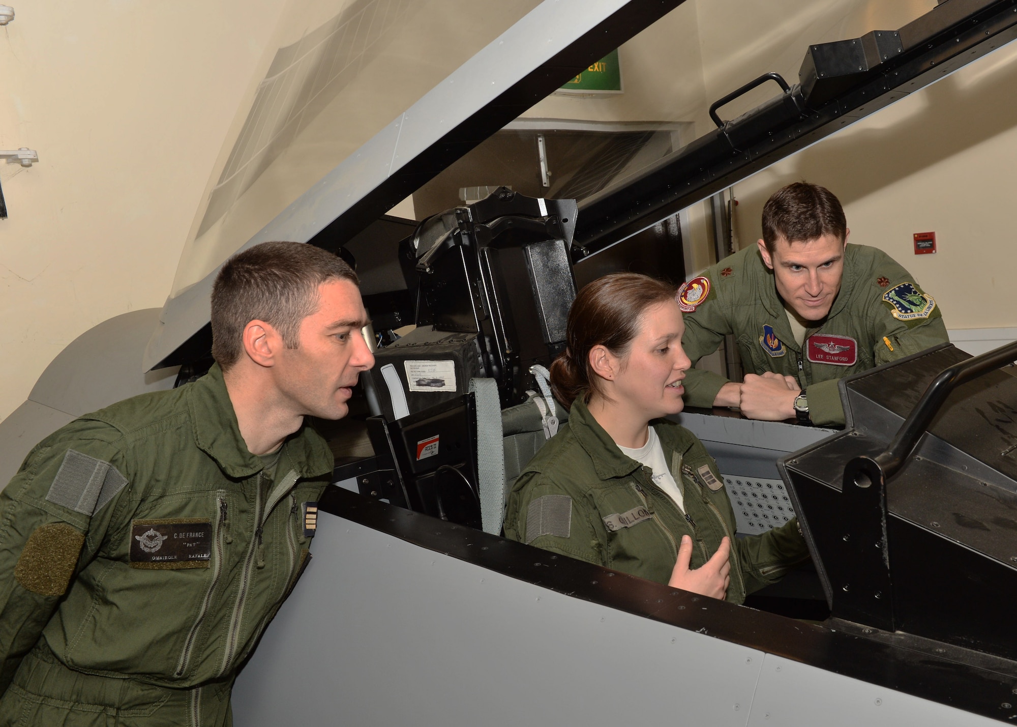 French air force pilots discuss the differences between the F-15E Strike Eagle and the Dassault Rafale, a twin-engine multi-role fighter aircraft commonly used in France during a visit to the RAF Lakenheath flight simulator, Oct. 4, 2013. The event was orchestrated to further strengthen the camaraderie between the U.S. and French forces. (U.S. Air Force photo by Airman 1st Class Nigel Sandridge/Released)