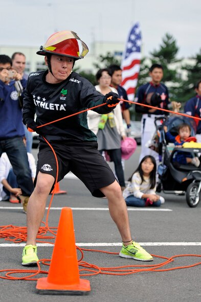 A member of the Towada City Fire Department pulls a Kiesser sled during the Fire Prevention Week opening ceremony at Misawa Air Base, Japan, Oct. 6, 2013. Members from local Japanese fire departments competed against base Airmen in the eighth annual fire muster to kick off Fire Prevention Week. (U.S. Air Force photo by Airman 1st Class Zachary Kee)