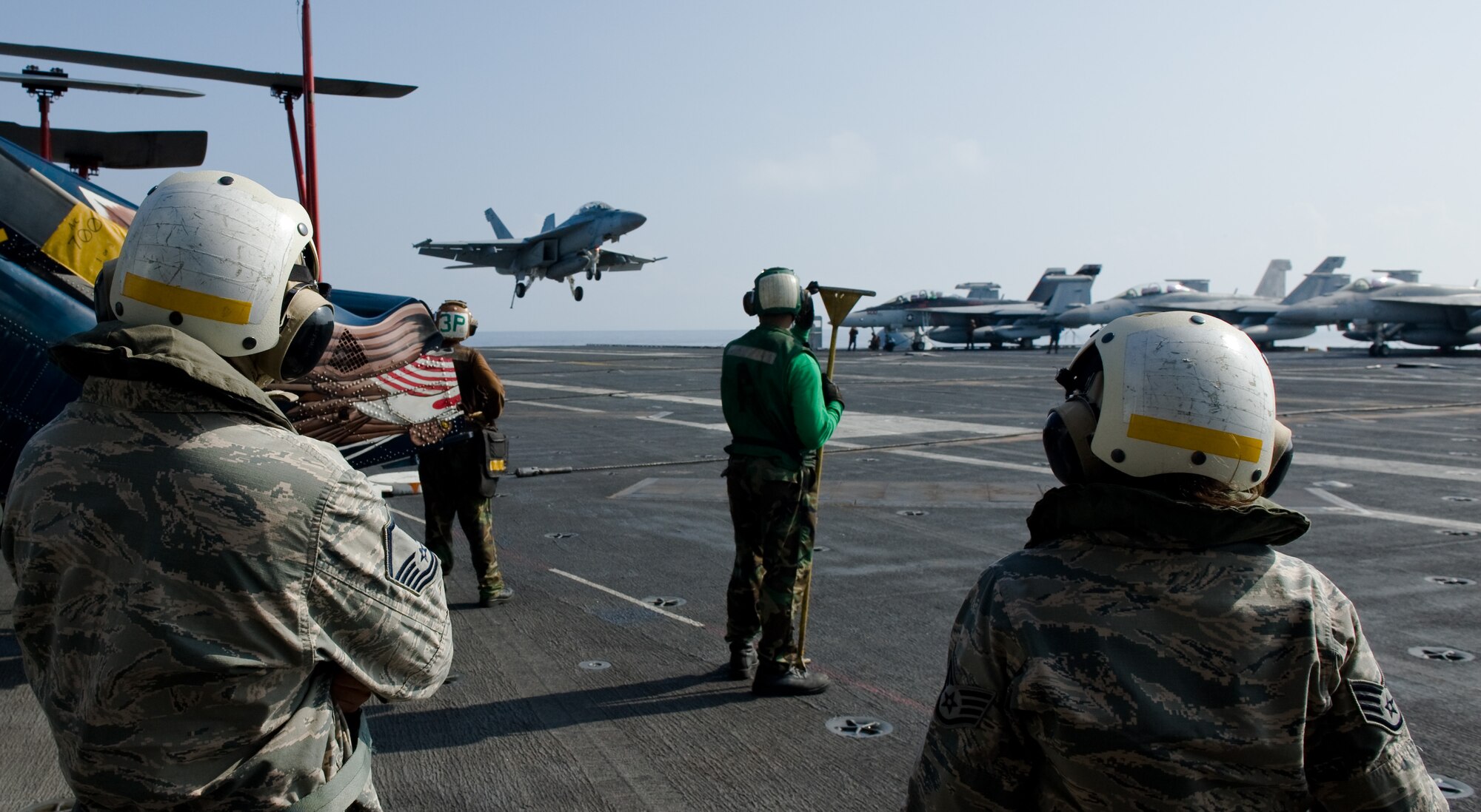 Airmen from the 8th Fighter Wing view a U.S. Navy F/A-18E Super Hornet make an arrested landing on the flight deck of the USS George Washington (CVN 73) Oct. 10, 2013. The Navy “Providers” of Fleet Logistics Support Squadron (VRC) 30 gave the Wolf Pack an opportunity to view both the Providers’ mission as well as the USS George Washington’s mission. (U.S. Air Force photo by Senior Airman Armando A. Schwier-Morales/Released)