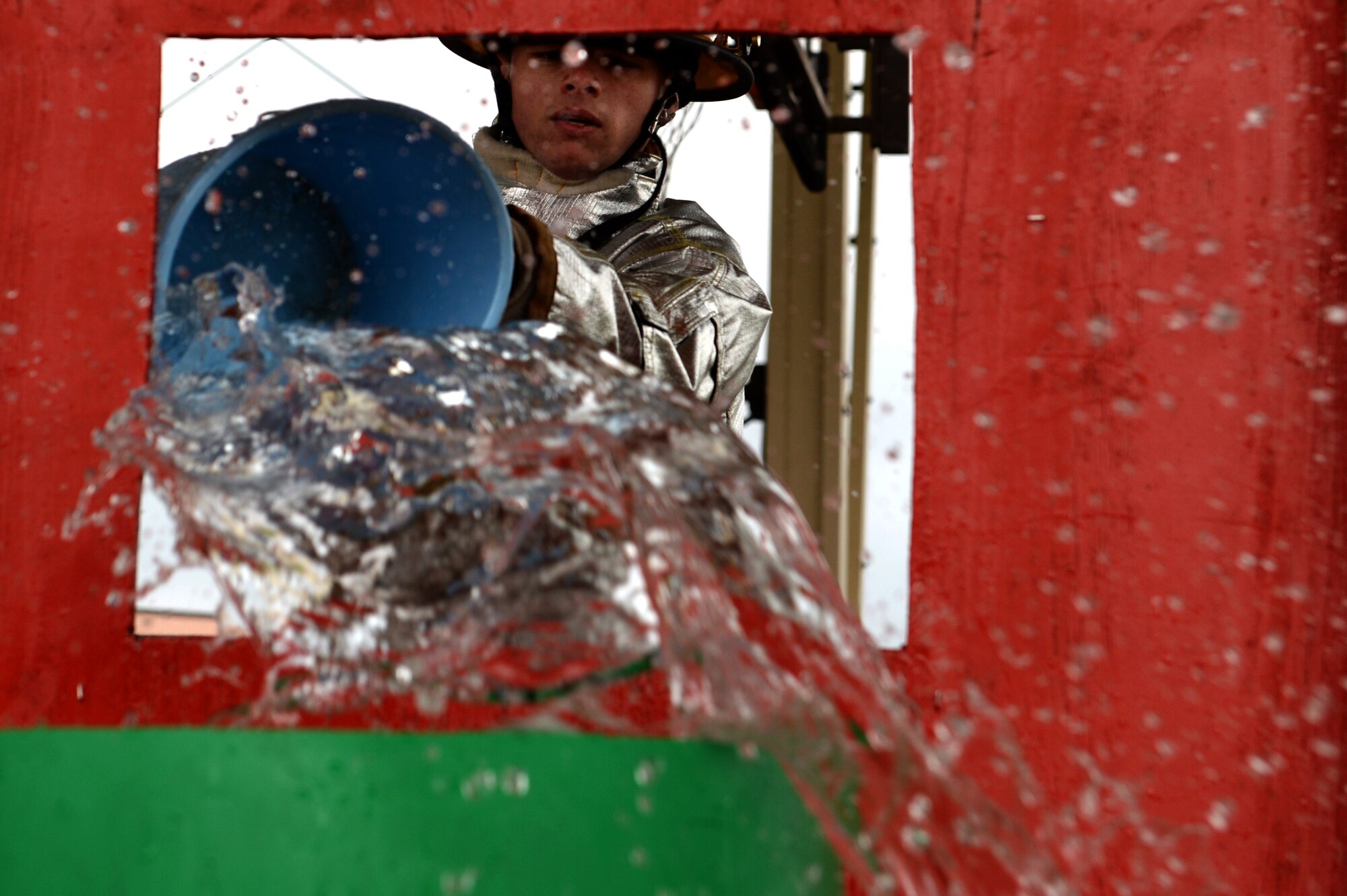 SPANGDAHLEM AIR BASE, Germany – Staff Sgt. Marshall Freitas, 52nd Equipment Maintenance Squadron crash recovery team supervisor from Virginia Beach, Va., pours water onto a simulated fire as part of the Spangdahlem Fire Prevention Week fire muster challenge Oct. 10, 2013. The fire muster gave Sabers from all units the opportunity to put their physical skills to the test in some activities fire fighters do every day. (U.S. Air Force photo by Senior Airman Alexis Siekert/Released)