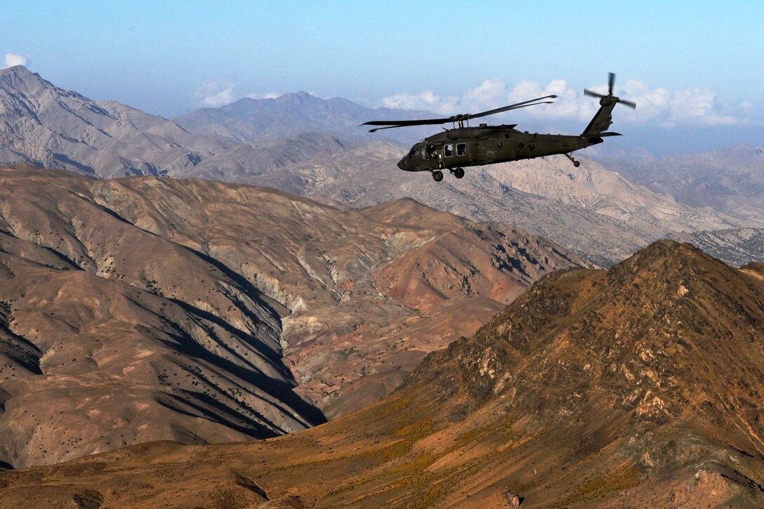 A UH-60 Black Hawk helicopter flies over a mountain range during a passenger movement in eastern Afghanistan, Oct. 9, 2013.