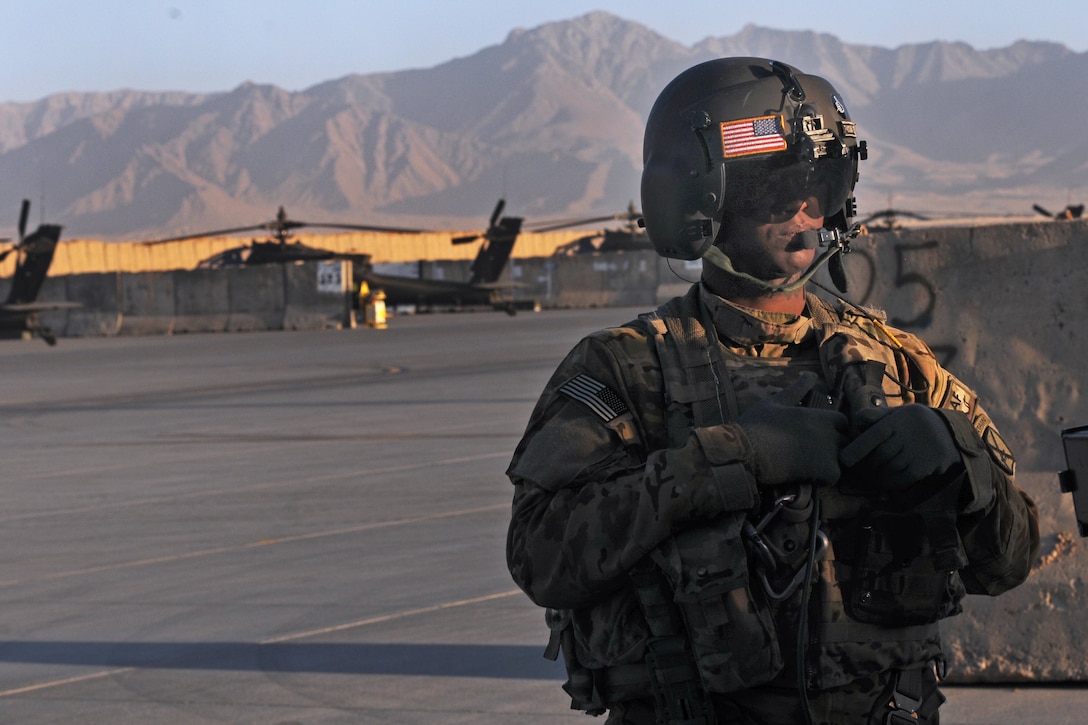 U.S. Army Spc. Mark Davis waits for a passenger to board a UH-60 Black Hawk helicopter during a mission on Forward Operating Base Shank in Logar province, Afghanistan, Oct. 9, 2013. Davis, a crew chief, is assigned to Company C, 2nd Battalion Assault, 10th Combat Aviation Brigade.