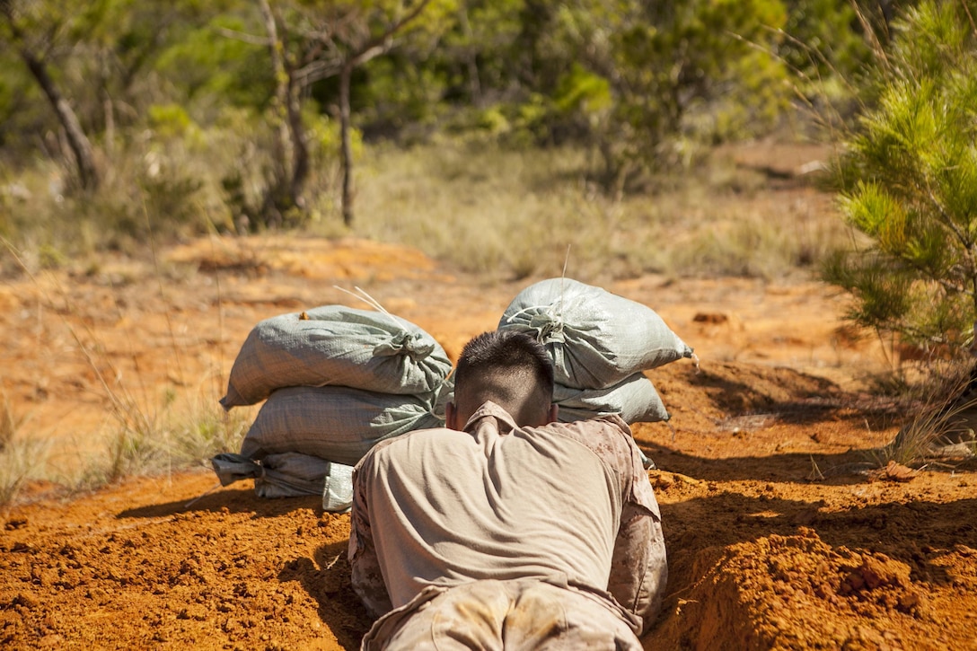 A Marine with Company E., Battalion Landing Team 2nd Battalion, 4th Marines, 31st Marine Expeditionary Unit, lays inside a freshly-dug fighting hole as part of a combat endurance test here, Oct. 10. The two-day test was performed across the base and evaluated a multitude of field skills and knowledge in a relay race competition. The Marines were tested on skills including: making range cards, gas mask drills, weapon assembly and disassembly and combat lifesaving procedures. The 31st MEU is the Marine Corps’ force in readiness in the Asia-Pacific region and the only continuously forward-deployed MEU.