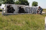 Army Sgt. 1st Class Charles Young, North Carolina National Guard member, observes as soldiers of the Moldovan army's 22nd Peace Keeping Battalion crouch after hearing the alarm for an explosion device found on their mock base during a training exercise here June 24, 2011. The 22nd PKB soldiers participated in exercises to show off their capabilities as a unit before their NATO evaluation, a weeklong exercise called Peace Shield 2011 that kicked off June 27.