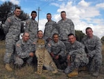 New York National Guard members visit with a tame cheetah at a South African game preserve during their recent trip there for the South African National Defense Force 2011 Regional Combat Rifle Competition.