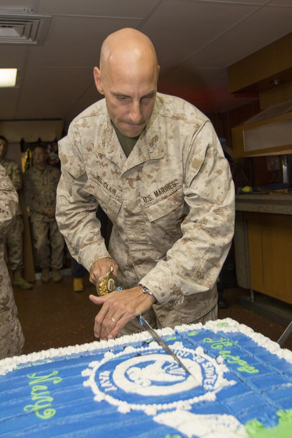 U.S. Marine Corps Col. Matthew G. St. Clair, 26th Marine Expeditionary Unit (MEU) commanding officer, cuts a cake to honor the birthdays of the U.S. Marine Corps and U.S. Navy during a cake cutting ceremony, in the mess deck of the USS Kearsarge (LHD 3), at sea, Oct. 16, 2013. The 26th Marine Expeditionary Unit is a Marine Air-Ground Task Force forward-deployed to the U.S. 6th Fleet area of responsibility aboard the Kearsarge Amphibious Ready Group serving as a sea-based, expeditionary crisis response force capable of conducting amphibious operations across the full range of military operations. (U.S. Marine Corps photo by Cpl. Kyle N. Runnels/Released)
