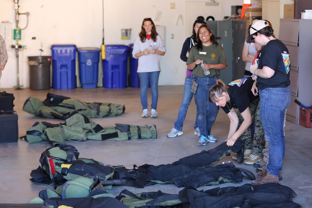 Spouses from Headquarters and Headquarters Squadron become familiar with the Explosive Ordnance Disposal suits during Jane Wayne Day aboard Marine Corps Air Station Miramar, Calif., Oct. 11. The spouses tried on the suits and walked around learning the difficulties of being in the suit.