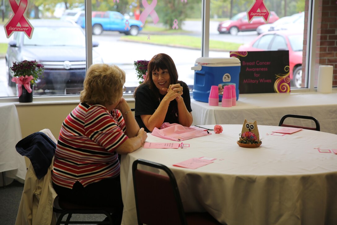 Two breast cancer survivors share stories at the Breast Cancer Awareness Luncheon aboard Marine Corps Base Camp Lejeune, Oct. 10. Representatives from the local community and Naval Hospital Camp Lejeune support breast cancer survivors and recently diagnosed breast cancer patients with information on the latest treatments.