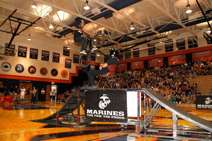 Mykel Larrin, a BMX rider, performs a high-risk jump over Jimmy Walker, a fellow BMX rider, during the 2013 ASA High School Tour at the Olathe East High School gymnasium Sept. 12, 2013. The ASA High School Tour travels across the country advocating an anti-bullying and anti-tobacco message. The tour stopped at several schools in the Recruting Station Kansas City area.