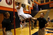 A high school student attempts to perform a pull-up as Marines from Recruiting Sub-station Olathe look on during the 2013 ASA High School Tour at the Olathe East High School gymnasium Sept. 12, 2013. The Marine Corps and ASA have partnered for several years to spread the message of anti-bullying and anti-tobacco. 