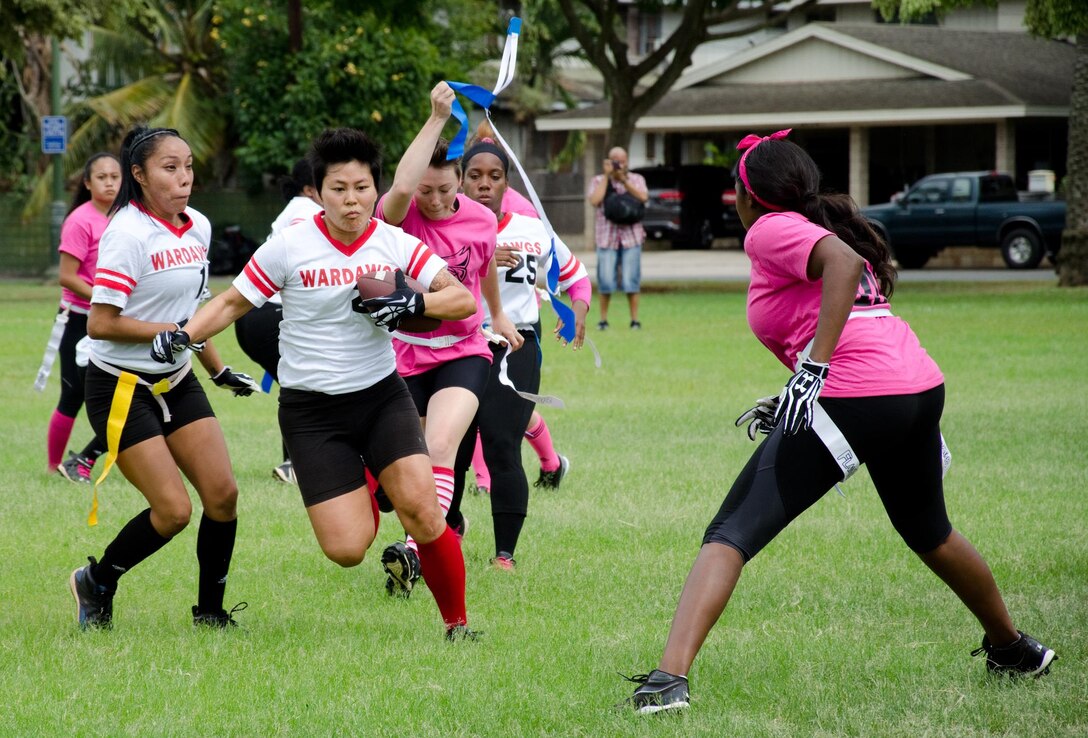 WarDawgs wide receiver Shannon Nagasako runs with the ball as the Falcons attempt to take her flag during a Hawaii Gridiron League game at Kapiolani Park, Oct. 6, 2013. (U.S. Marine Corps photo by Kristen Wong)