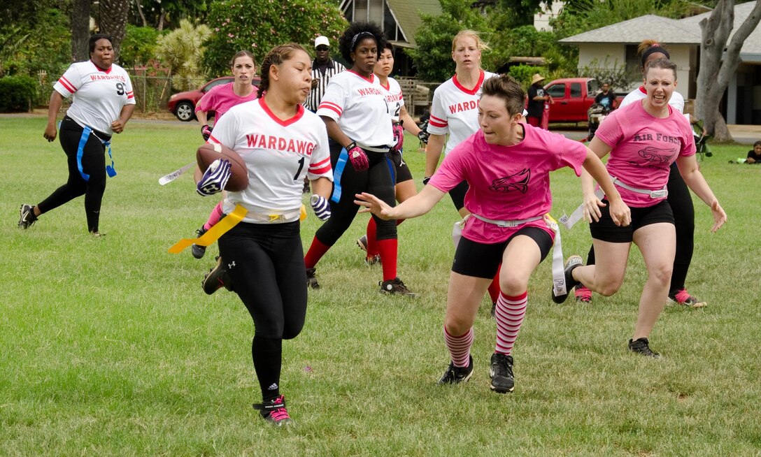 WarDawgs running back Amanda Luna attempts to advance with the ball as the Falcons attempt to take her flag during a Hawaii Gridiron League game at Kapiolani Park, Oct. 6, 2013. (U.S. Marine Corps photo by Kristen Wong)