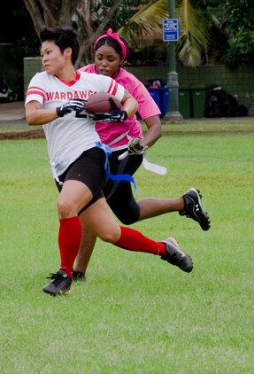 WarDawgs wide receiver Shannon Nagasako advances as she gains possession of the ball as a Falcons' player attempts to take her flag during a Hawaii Gridiron League game at Kapiolani Park, Oct. 6, 2013. (U.S. Marine Corps photo by Kristen Wong)