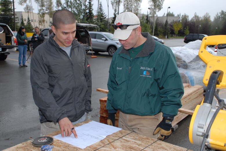 1st Lt. Dan Frederick, 2nd Engineer Brigade and project engineer for the Fisher House shed project, discusses the plans with Maj. Mark DeRocchi, deputy commander of the U.S. Army Corps of Engineers - Alaska District, Sept. 13 during the first Saturday of constructing a much needed storage shed for the Fisher House of Alaska located at Joint Base Elmendorf-Richardson.