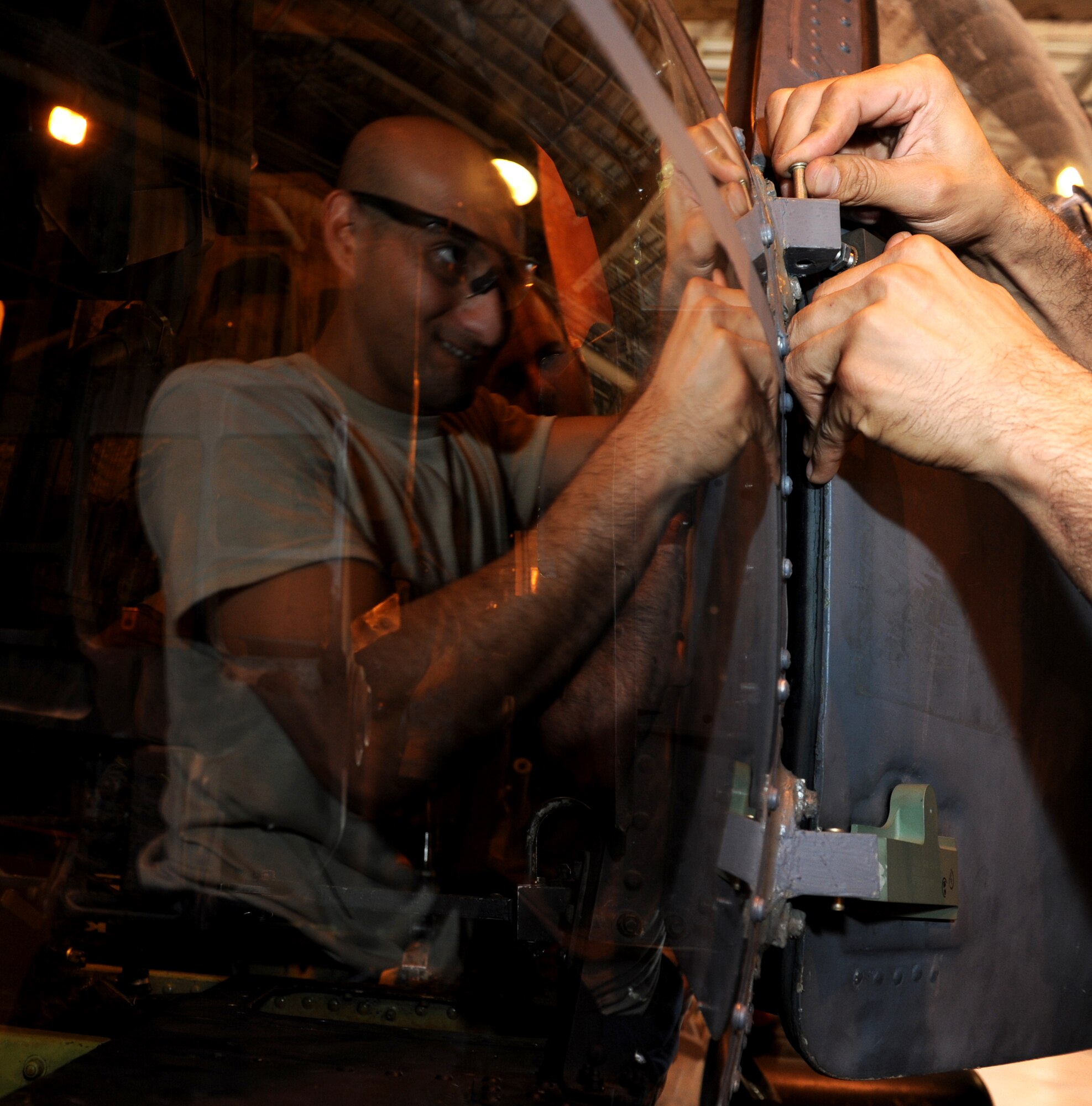 U.S. Air Force Staff Sgt. Joshua Alvarez, 33rd Helicopter Maintenance Unit HH-60G Pave Hawk crew chief, installs a co-pilot cockpit door on a Pave Hawk and adjusts its hinges on Oct. 15, 2013 on Kadena Air Base, Japan. The support that the 33rd HMU provides to the 33rd Rescue Squadron is vital to keeping their aircraft mission ready for exercise training, search and rescue efforts, and real world mission contingency operations throughout the Pacific theater. (U.S. Air Force photo by Airman 1st Class Keith A. James)